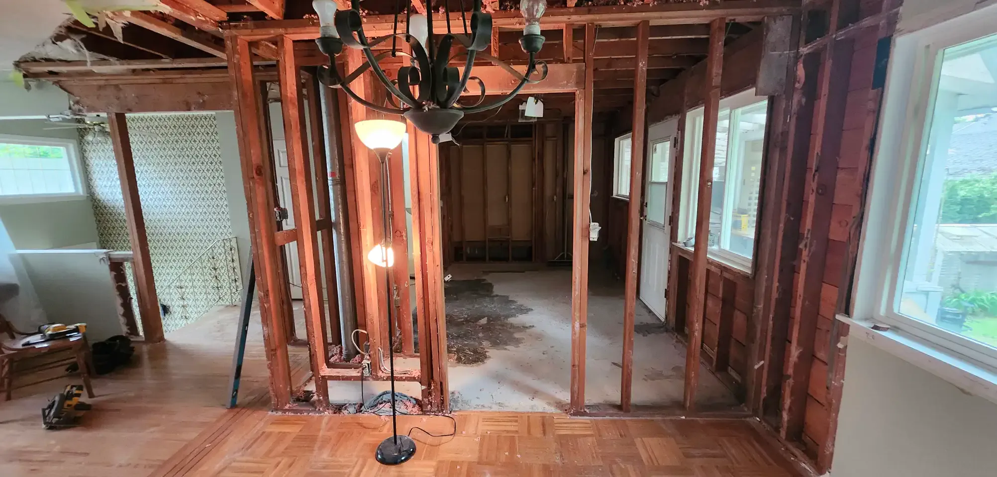 Interior house renovation in Maple Ridge showing exposed wall studs and open ceiling framing during interior demolition by PCC.
