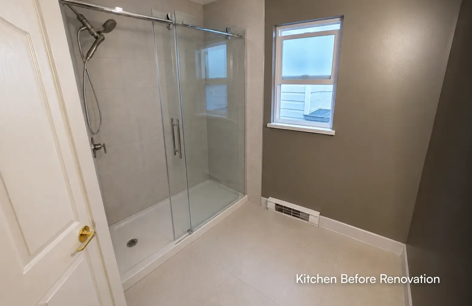 A view inside a newly renovated bathroom focusing on a walk-in shower with large tiled walls, a sliding glass door, and brushed nickel fixtures by Pacific Coast Contracting.