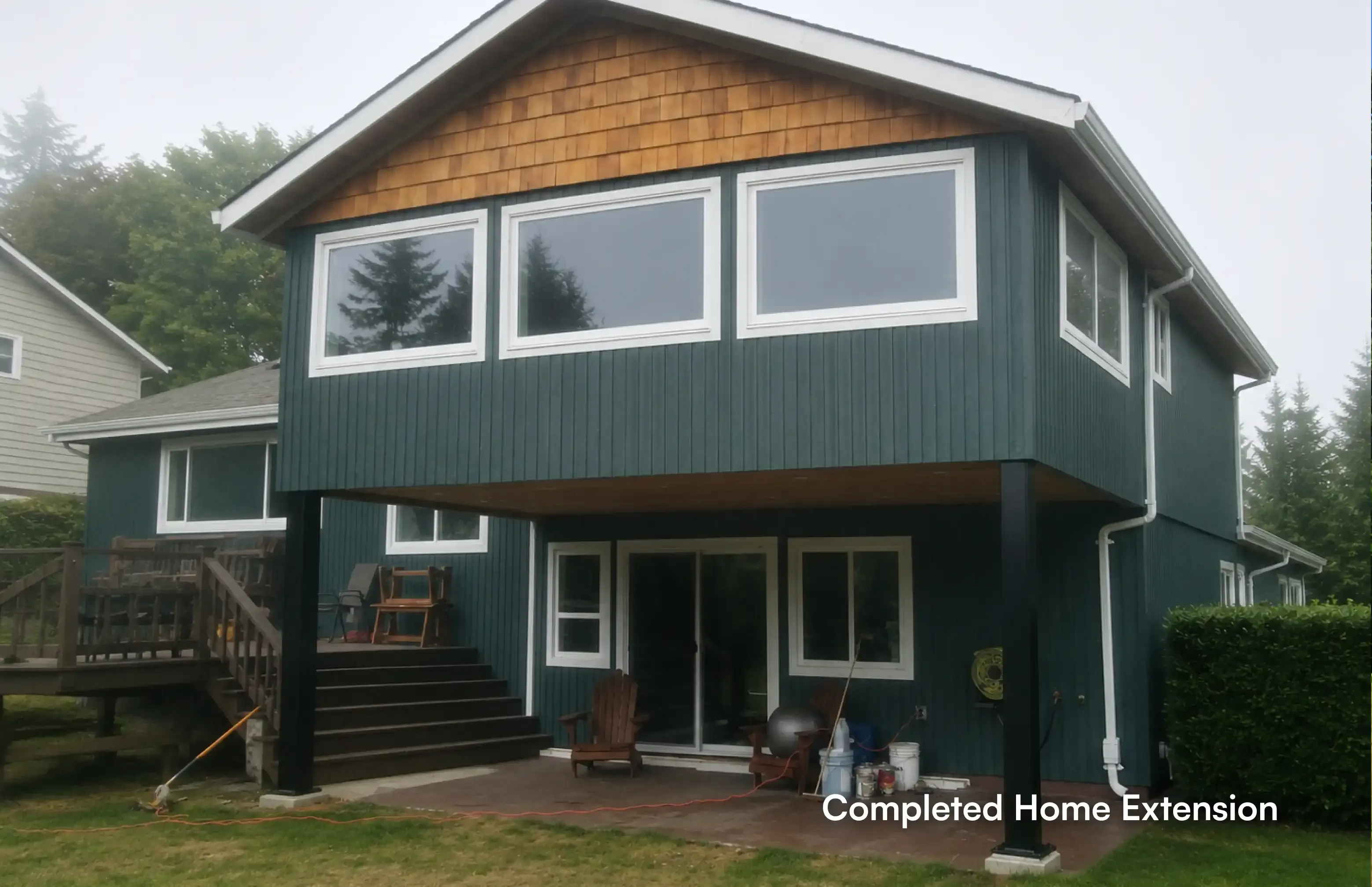 Front elevation view of a completed residential home extension in Coquitlam by Pacific Coast Contracting, showcasing a modernized exterior supported by black structural pillars by PCC - Pacific Coast Contracting Renovations.