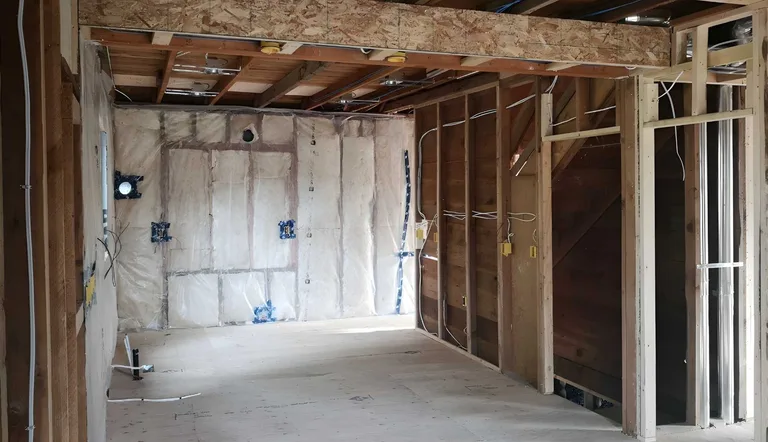 Interior wall framing with insulation and electrical boxes before the interior renovation in Maple Ridge, BC by PCC Renovations.