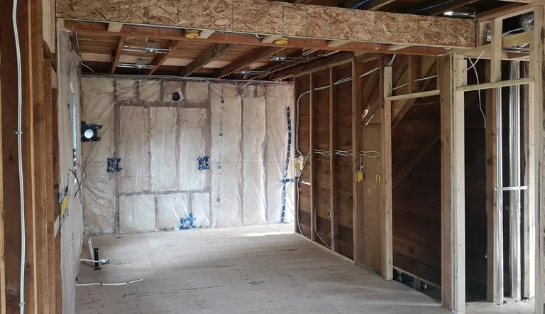 Interior wall framing with insulation and electrical boxes before the interior renovation in Maple Ridge, BC by PCC Renovations.