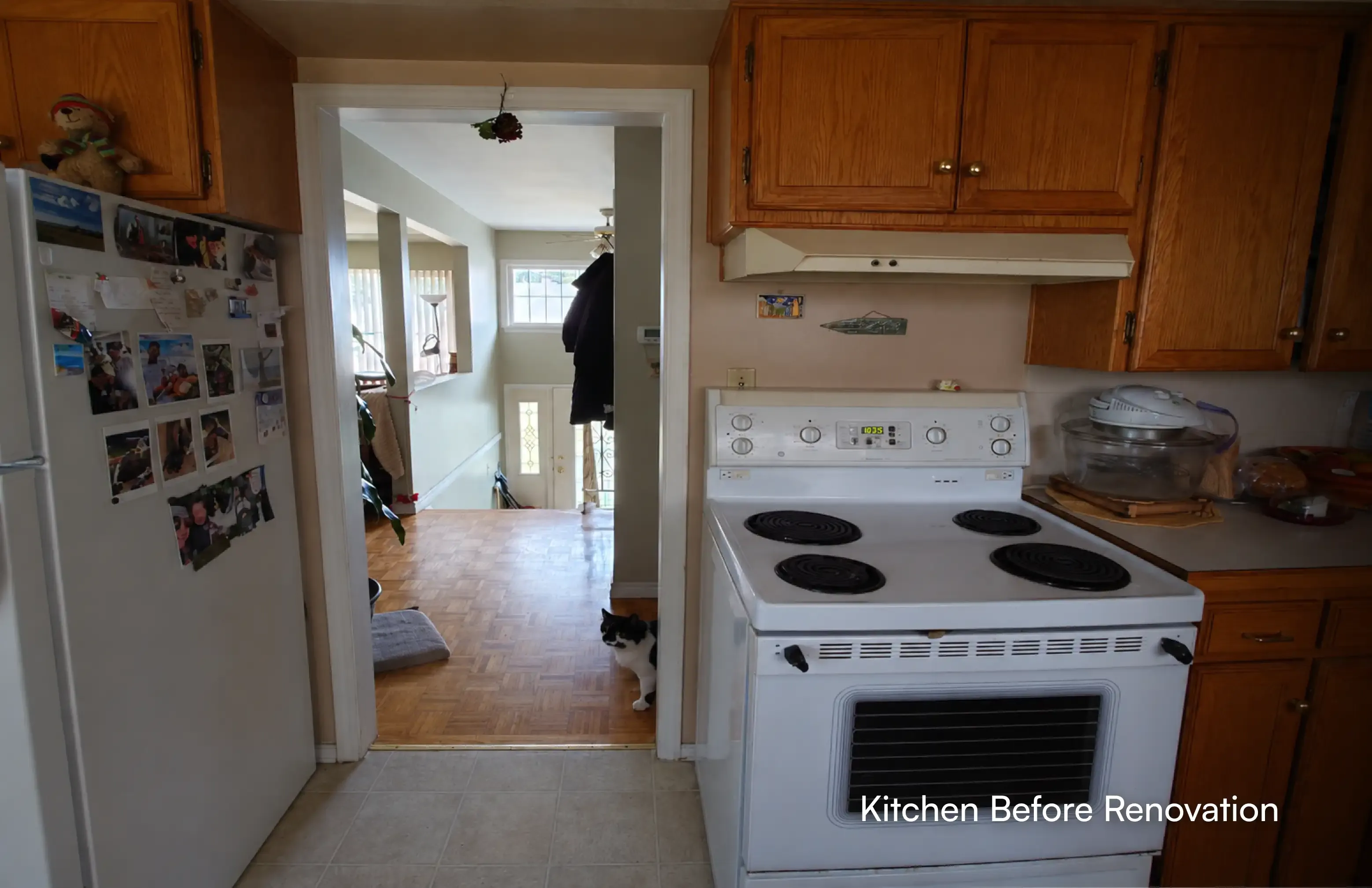 Angle view of an unrenovated kitchen with a white electric stove and wooden cabinets before full interior remodeling in Maple Ridge by PCC - Pacific Coast Contracting.