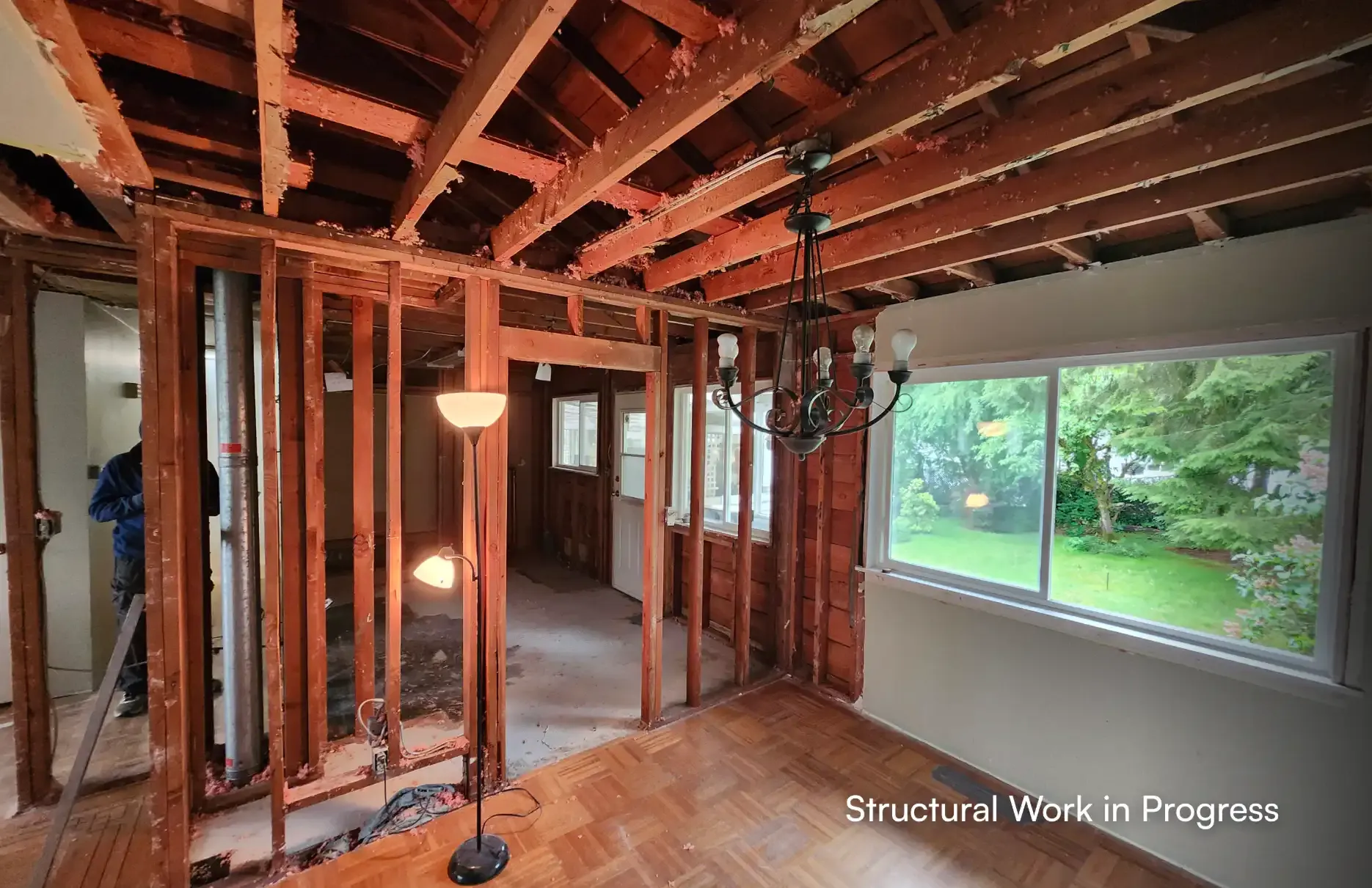 Structural interior renovation work in progress showing open wall studs, exposed joists, and new layout framing by Pacific Coast Contracting (PCC) in Maple Ridge.