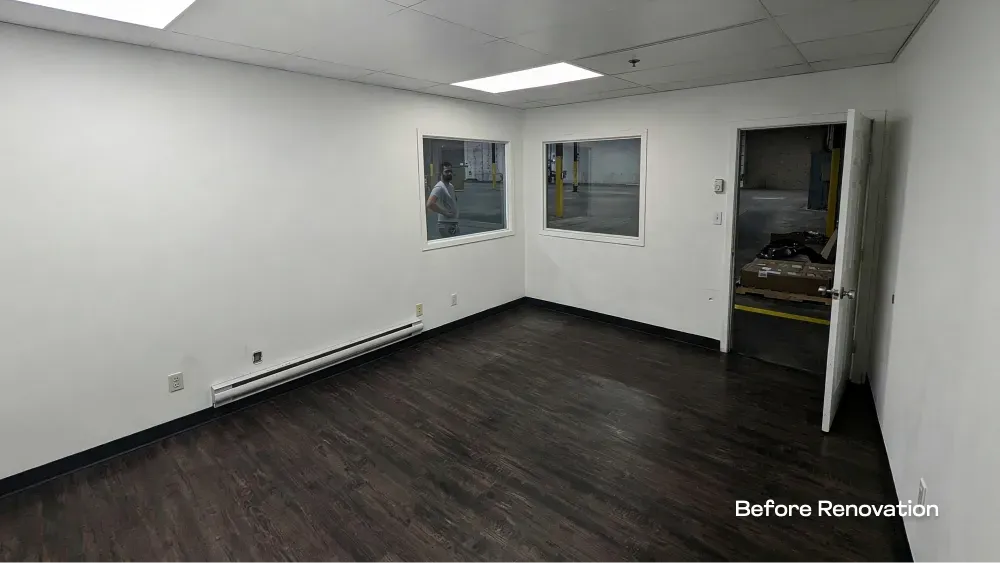 Before renovation view of an interior commercial office space looking out into the attached warehouse facility.