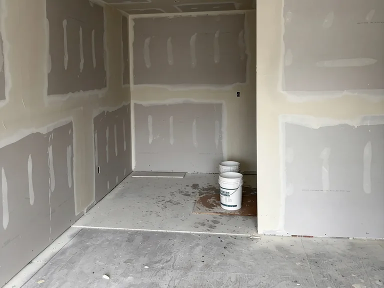 Drywall finishing coats in a condo room during a fire restoration in Chilliwack, BC by PCC Contracting.