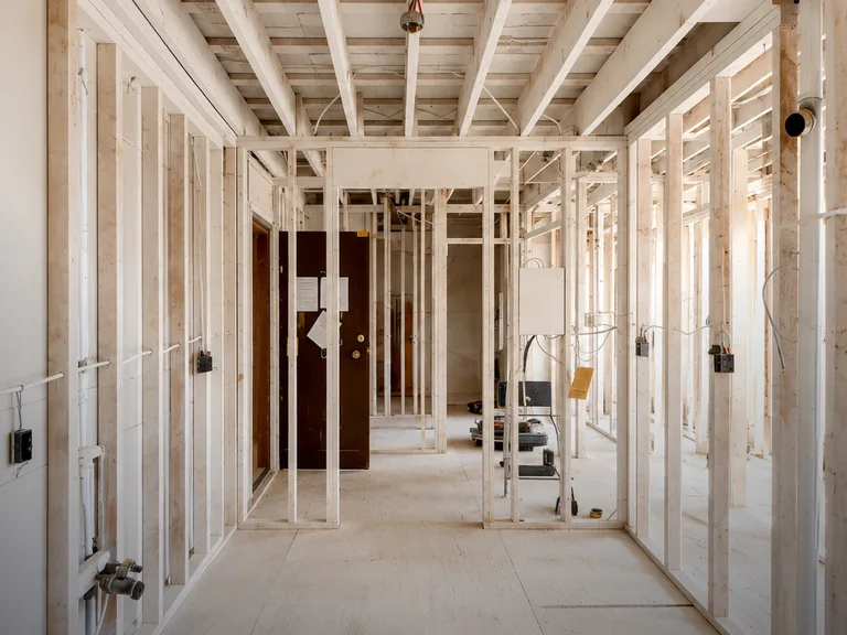 New wall framing and ceiling joists in a corridor during a condo fire restoration in Chilliwack, BC by PCC Contracting.