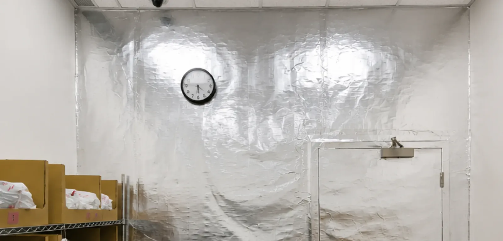 Close-up view of metallic RFID shielding foil installed on a commercial stockroom wall, a specialized retail renovation service provided by Pacific Coast Contracting (PCC).