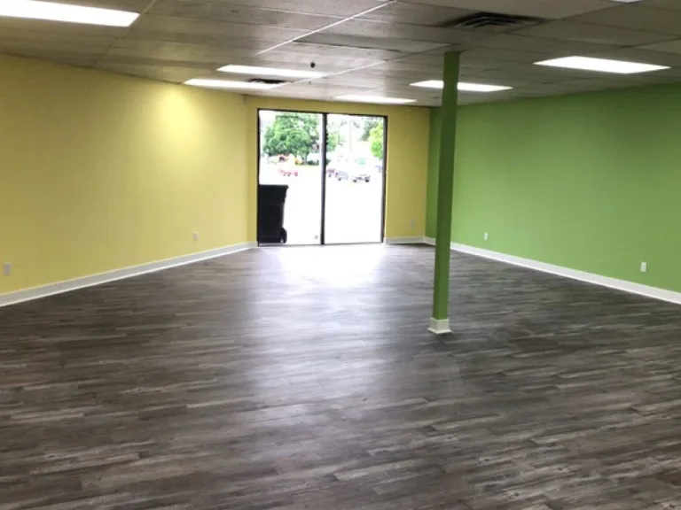 Open day care play room with yellow and green painted walls and new flooring in Port Coquitlam, BC