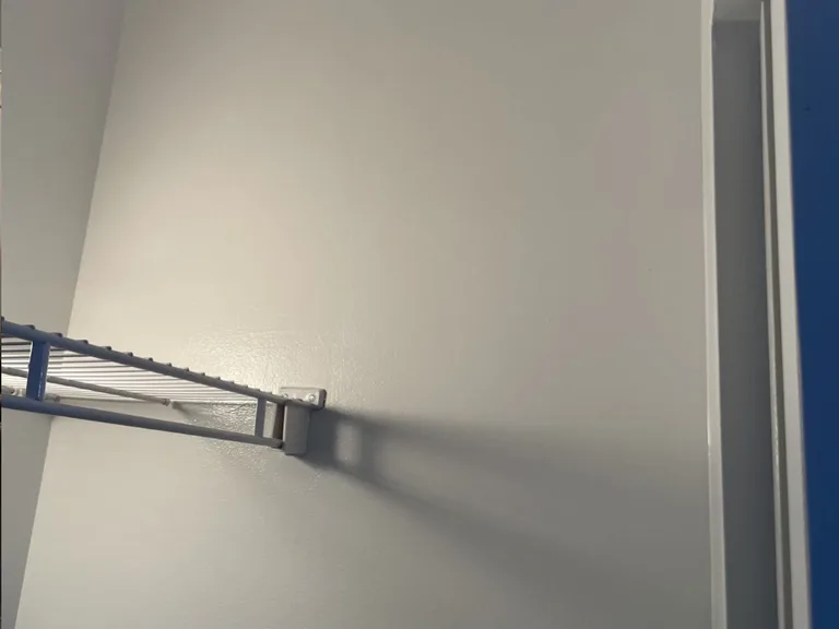 Smooth repaired and painted drywall next to a closet shelf after drywall repair in Port Moody, BC by PCC Contracting. — after