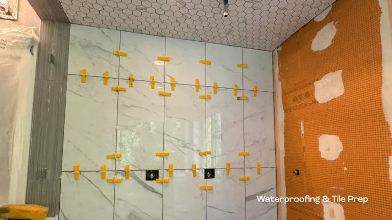 Waterproofing membranes and marble-style wall tile installation in progress for a high-end bathroom remodel by PCC.
