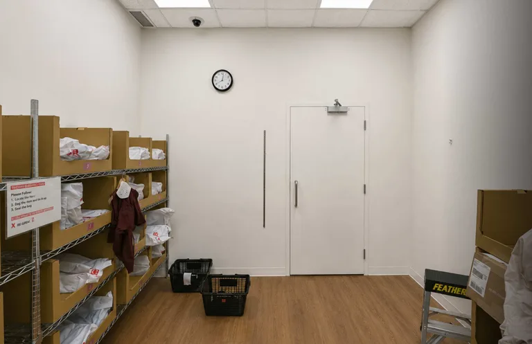 Retail back room with plain white walls and a door before RFID shielding installation in Coquitlam, BC by PCC Contracting. — before