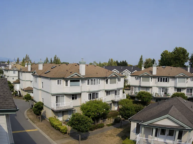 Residential townhouse complex in Richmond after roof replacement, with new roofing in clear weather