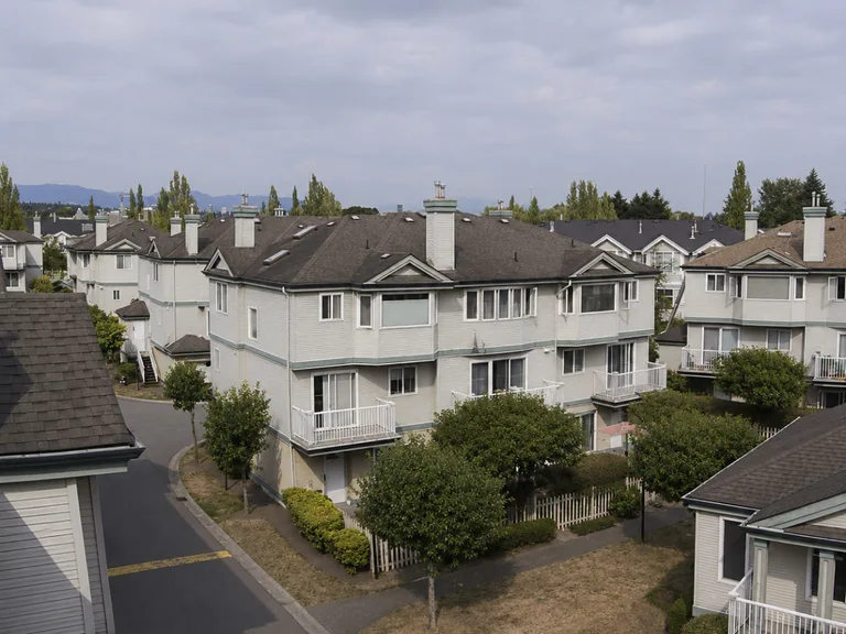 Residential townhouse complex in Richmond before roof replacement, with aged roofing under an overcast sky